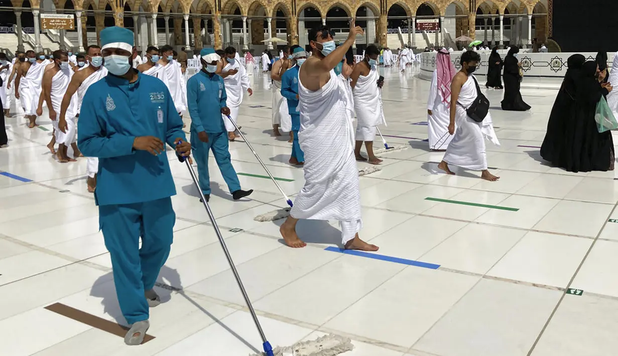 Pekerja mendisinfeksi area sekitar Kakbah untuk membantu menghentikan penyebaran virus corona COVID-19 saat umat muslim melaksanakan umrah di Masjidil Haram, Makkah, Arab Saudi, Minggu (30/5/2021). (AP Photo/Amr Nabil)