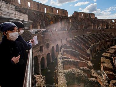 Wisatawan mengunjungi Colosseum di Roma, Sabtu (7/3/2020). Kekhwatiran terhadap virus corona (COVID-19) membuat tempat-tempat pariwisata di Italia sepi pengunjung, seperti di kawasan Colosseum yang merupakan salah satu dari keajaiban dunia. (AP Photo/Andrew Medichini)