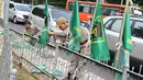 Petugas Satpol PP mencopot bendera partai politik di sepanjang pagar kawasan Pancoran, Jakarta. Selasa (18/7). Pencopotan dilakukan untuk menertibkan bendera partai politik liar yang memenuhi ruang publik di Ibukota. (Liputan6.com/Immanuel Antonius)