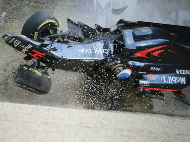 Pebalap McLaren Honda asal Spanyol, Fernando Alonso, mengalami kecelakaan setelah menabrak pebalap Haas F1, Esteban Gutierrez, dan tembok pembatas dalam F1 GP Australia di Sirkuit Albert Park, Minggu (20/3/2016). (AFP/Newspix/Alex Coppel)