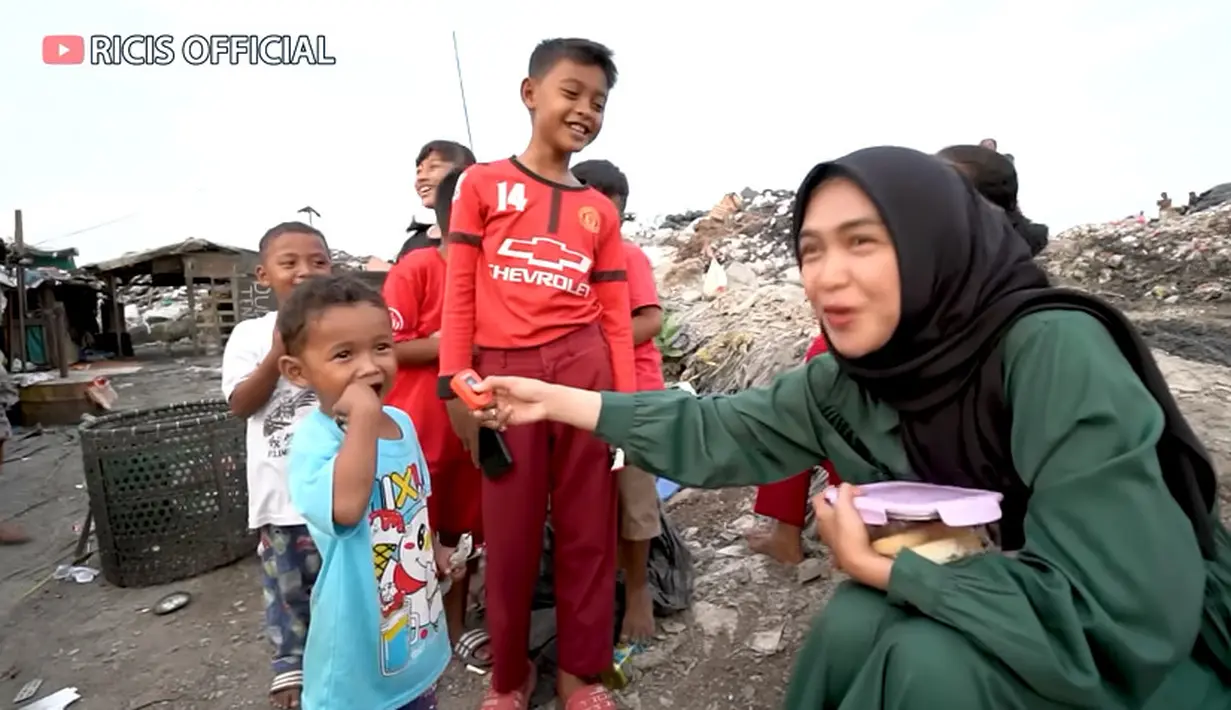 Karena tak ada warung nasi di sekitar tempat tersebut, Ricis akhirnya mengambil cemilan hingga buah yang ada di mobilnya. Ia kemudian mengajak ibu-ibu dan anak-anak untuk makan bareng. [Youtube/Ricis Official]