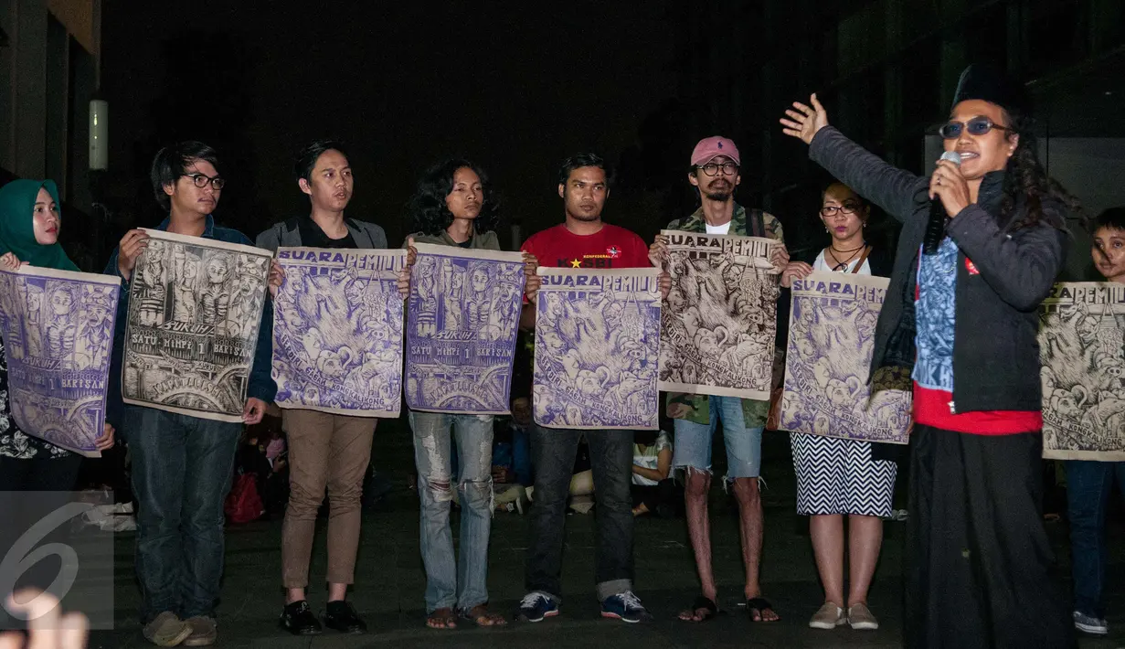 Para simpatisan memegang poster hasil puisi yang digambarkan dari Sastrawan dan Aktivis HAM Widji Thukul, Wahyu Susilo membacakan puisi - puisi karya Widji Thukul di Taman Ismail Marzuki, Jakarta, Selasa (24/1). (Liputan6.com/Gempur M Surya)