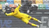 Kiper AC Milan, Gianluigi Donnarumma, berusaha menghalau bola saat melawan Udinese pada laga Liga Italia di Stadion Friuli, Minggu (1/11/2020). AC Milan menang dengan skor 2-1. (Andrea Bressanutti/LaPresse via AP)