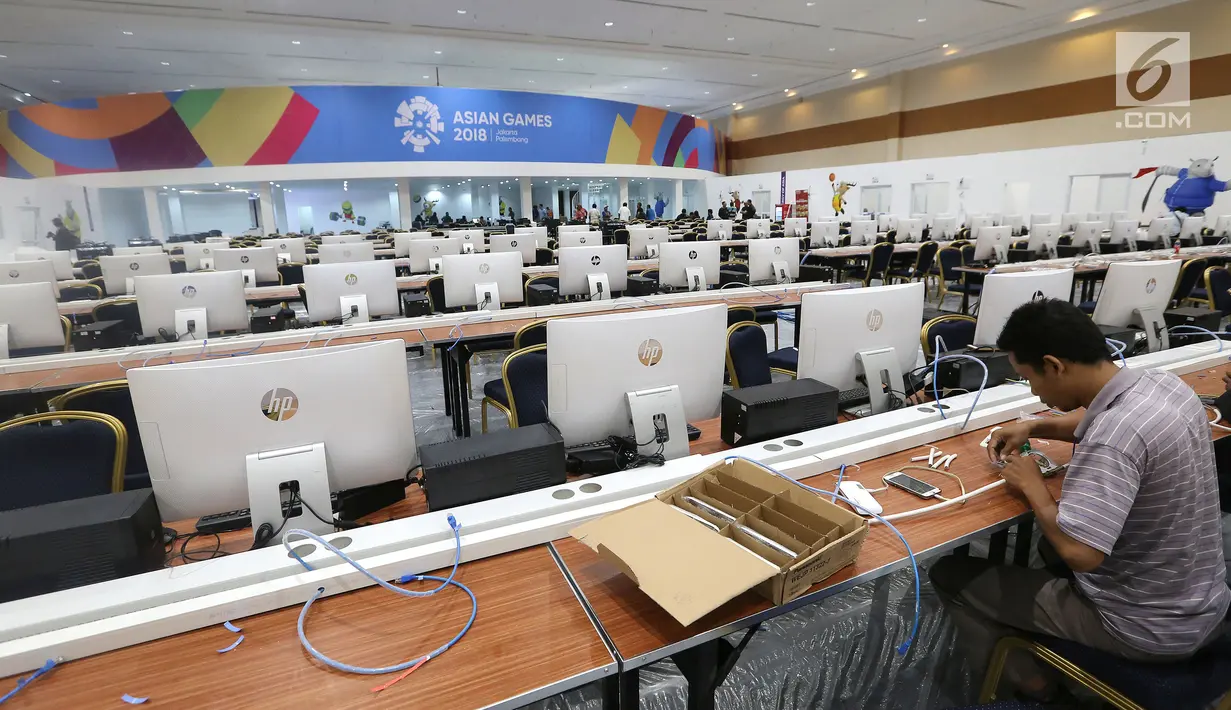 Pekerja sedang membuat jaringan komputer untuk jurnalis media nasional dan luar negeri pada pelaksanaan Asian Games 2018 di Main Press Center (MPC) atau media center Exhibition Hall JCC, Jakarta, Kamis (9/8). (Liputan6.com/Fery Pradolo)