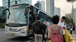 Warga menaiki angkutan umum di tepi Jalan Jenderal Sudirman, Jakarta, Senin (8/7/2019). Tidak adanya halte tersebut mengurangi kenyamanan serta mengganggu arus lalu lintas. (Liputan6.com/Immanuel Antonius)