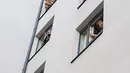 Para tamu Zeitgeist Hotel menikmati dari kamar mereka penampilan penyanyi Monika Medek dan Dagmar Dekanovsky serta orkestra Camerata Carnutum di Wina, Sabtu (30/5/2020). "Konser jendela" diadakan untuk merayakan pembukaan kembali hotel di Austria di tengah pandemi COVID-19. (JOE KLAMAR/AFP)