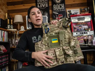 Foto yang diambil pada 20 Maret 2023 ini menunjukkan manajer tempat mahjong Yuya Motomura, yang berencana untuk bergabung dengan Legiun Georgia untuk berperang di Ukraina, memegang jaket militer saat dia berbicara selama wawancara dengan AFP di Maebashi, prefektur Gunma. (Yuichi YAMAZAKI / AFP)