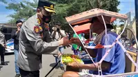 Kapolresta Banyuwangi Kombes Pol Deddy Foury Millewa  Bagikan paket sembako ke Tukang becak dan masyarakat lainya di Banyuwangi. (Hermawan Arifianto/Liputan6.com)