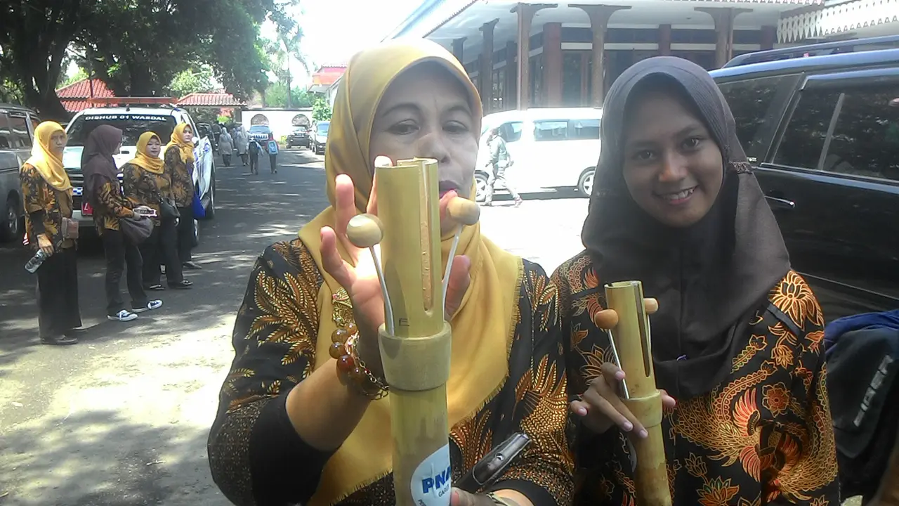 Salah seorang siswa dan pengajarnya tengah menunjukan salah satu contoh alat musik Celentung dari Selaawi, Garut