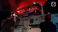 Warga merekam suasana kebakaran yang melanda pertokoan Glodok Plaza, Jakarta, Rabu (15/1/2025). (Liputan6.com/Herman Zakharia)