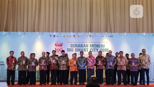 Menkominfo Johnny G. Plate berfoto bersama Wali Kota dan Kabupaten yang menerapkan konsep smart city di seluruh Indonesia dalam acara Gerakan Menuju 100 Smart City di Jakarta, Rabu (6/11/2019). (Liputan6.com/ Agustin Setyo W).