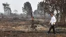 Presiden Joko Widodo atau Jokowi memeriksa kerusakan akibat kebakaran hutan dan lahan (karhutla) di Pekanbaru, Riau, Selasa (17/9/2019). Tanpa mengenakan masker, Jokowi turun langsung ke lahan gambut yang sudah habis terbakar. (Handout/Indonesian Presidential Palace/AFP)