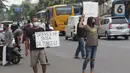 Penjual jasa perbaikan telepon genggam menawarkan jasa di pinggir jalan Mayjen Sutoyo depan Mall Pusat Grosir Cililitan (PGC), Jakarta, Rabu (14/7/2021). Kios yang biasa mereka tempati tutup seiring penutupan Mall PGC selama pemberlakuan PPKM Darurat Jawa-Bali. (Liputan6.com/Helmi Fithriansyah)