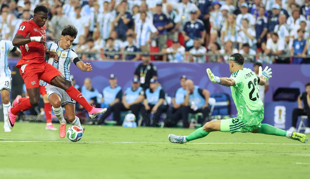 Pemain Swiss Breel Embolo berebut bola dengan pemain Argentina Lisandro Martinez, sementara kiper Argentina Emiliano Martinez mempertahankan gawangnya selama pertandingan perempat final Piala Dunia 2026 antara Argentina dan Swiss di Stadion Kansas City, Kansas City,  11 Juli 2026. (AFP/ Thomas Coex)