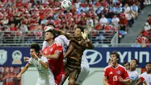 Penjaga gawang Thailand, Kampon Phatomakkakul (tengah), menghalangi pemain Singapura, Irfan Fandi Ahmad (2K), pada leg pertama pertandingan semifinal Piala AFF 2026 antara Singapura dan Thailand di Stadion Jalan Besar di Singapura pada 15 Agustus 2026. (Suhaimi Abdullah/AFP)