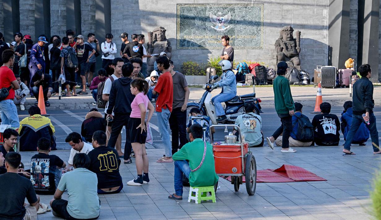 Menurut pihak KBRI di Phnom Penh, Kamboja, gelombang kedatangan terbesar terjadi pada Senin (19/1/2026) yakni sebanyak 520 WNI. Tampak dalam foto, orang-orang berkumpul di depan Kedutaan Besar Republik Indonesia (KBRI) di Phnom Penh, Kamboja, pada Rabu 21 Januari 2026. (TANG CHHIN Sothy/AFP)