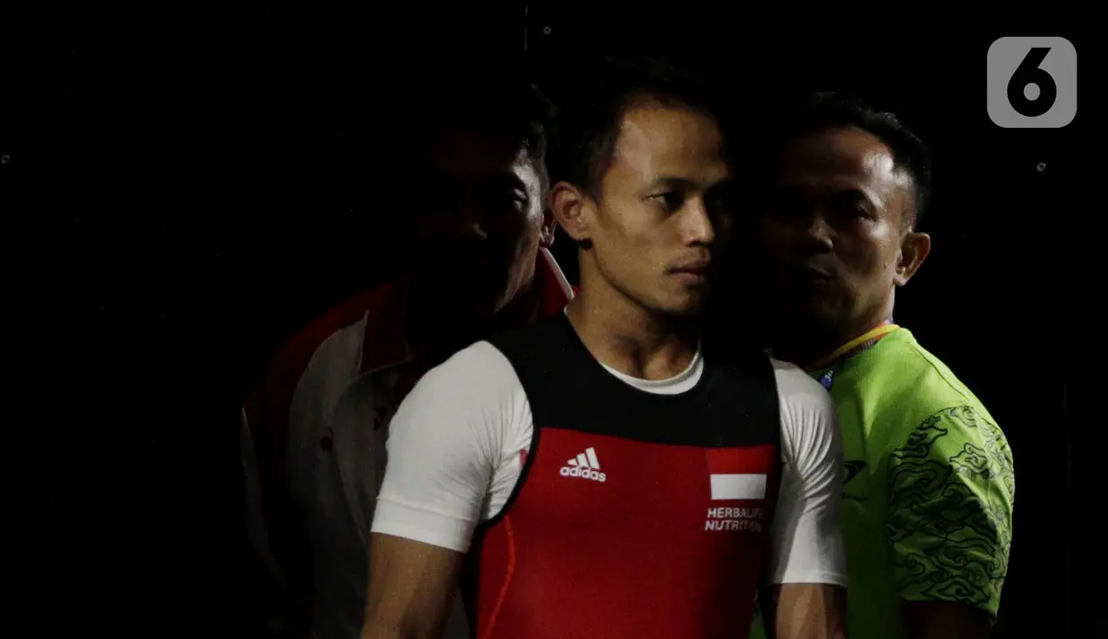 Lifter putra Indonesia, Suratman bersiap melakukan angkatan saat SEA Games 2019 cabang angkat besi nomor 55 kg di Stadion Rizal Memorial, Manila, Minggu (1/12/2019). Dirinya meraih perak dengan total angkatan 250 kg. (Bola.com/M Iqbal Ichsan)