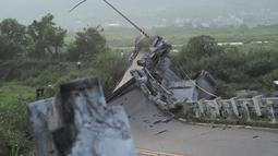 Wartawan berkumpul di samping jembatan Kaoliao yang runtuh di wilayah Hualien Taiwan timur (19/9/2022). Belum ada laporan korban jiwa akibat bencana alam tersebut. (AFP/Sam Yeh)