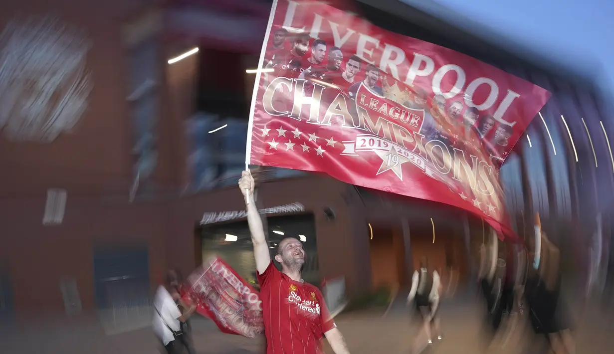 Suporter Liverpool merayakan gelar juara Premier League di depan Stadion Anfield, Kamis (25/6/2020). Titel juara Liga Inggris 2019-20 ini merupakan gelar pertama Liverpool setelah puasa selama 30 tahun. (AP/Jon Super)