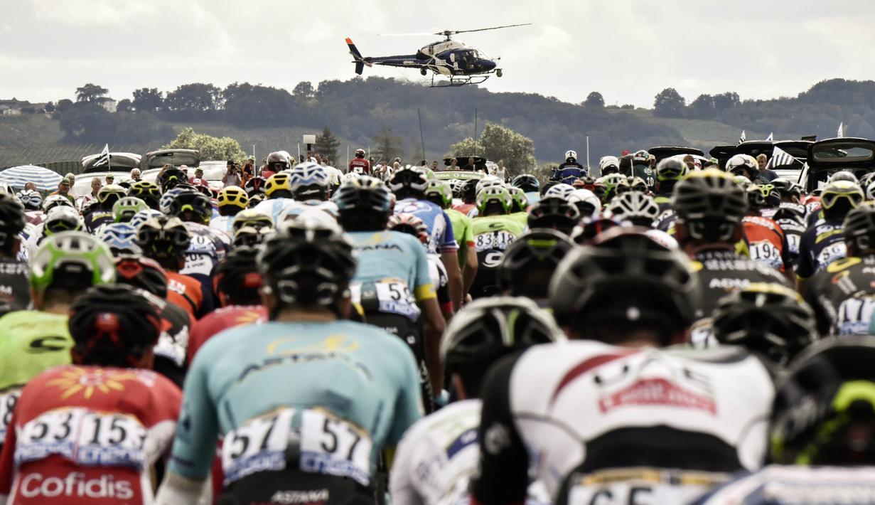 Sebuah Helikopter media melintas didepan pebalap Tour de France pada etape ke-10 antara Perigueux and Bergerac dengan jarak tempuh 178 km, (11/7/2017). (AFP/Jeff Pachoud)