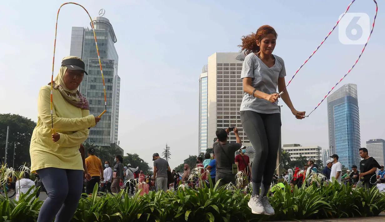Warga sedang mencoba olahraga lompat tali di kawasan bundaran Hotel Indonesia, Jakarta, Minggu (12/6/2022). Komunitas Jump Rode Indonesia mensosialisasikan olahraga lompat tali beberapa variasi gerakan ya bisa di pelajari seperti gerakan satu kaki. (Liputan6.com/Herman Zakharia)