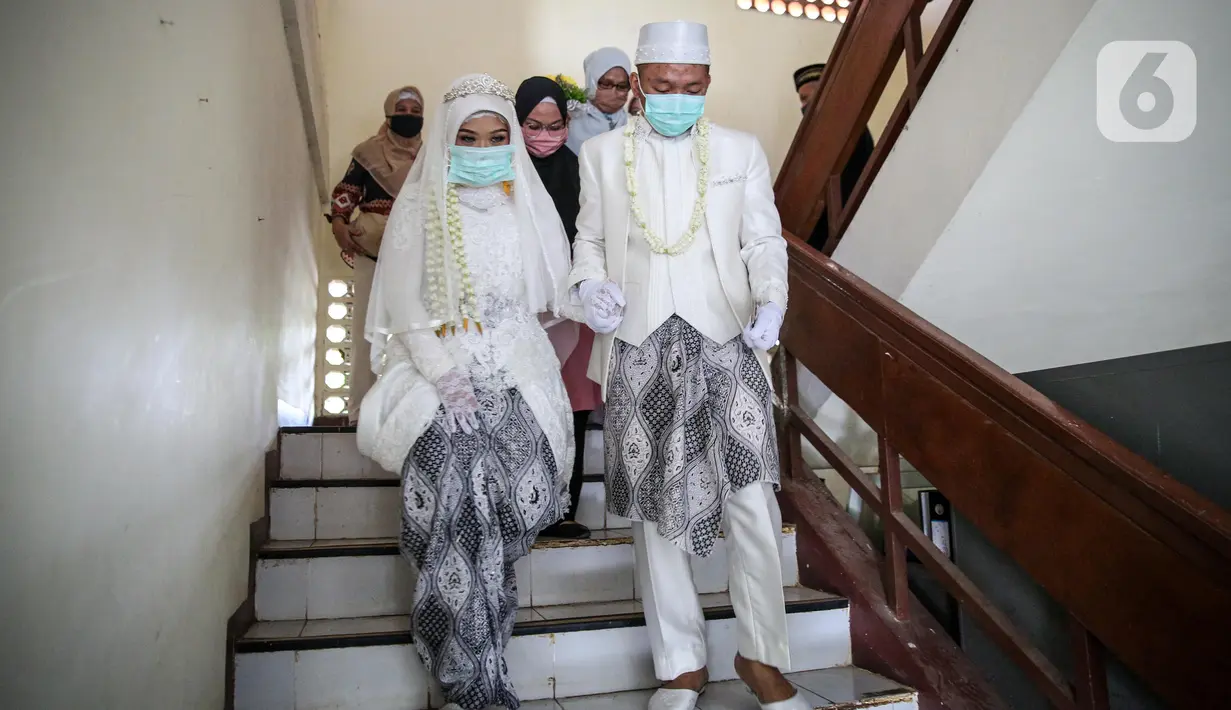 Pasangan pengantin usai melaksanakan prosesi akad nikah di KUA Jagakarsa, Jakarta, Sabtu (6/6/2020). Pernikahan mengikuti protokol kesehatan sesuai Surat Edaran (SE) Menteri Agama Nomor 15 Tahun 2020. (Liputan6.com/Faizal Fanani)