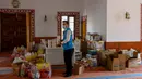 Imam masjid Dedeman, Abdulsamet Cakir (33) membawa barang-barang menuju pintu masjid di distrik Sariyer, Istanbul pada 21 April 2020. Di pintu masuk masjid itu dimana rak-rak yang biasanya diperuntukkan sebagai tempat sepatu jemaah, kini penuh dengan kebutuhan sehari-hari. (Bulent Kilic/AFP)