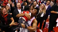 Pebasket Toronto Raptors, Kyle Lowry, menggendong putranya usai mengalahkan Milwaukee Bucks pada NBA Final Wilayah Timur di Scotiabank Arena, Toronto, Sabtu (25/5). Raptors menang 4-2 atas Bucks. (AFP/Gregory Shamus)