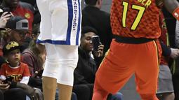 Aksi pemain Warriors, Stephen Curry melakukan tembakan melewati adangan pemain Atlanta Hawks, Dennis Schroder pada laga NBA basketball game  di Philips Arena, Atlanta, (2/3/2018). Warriors menang 114-109. (AP/John Amis)