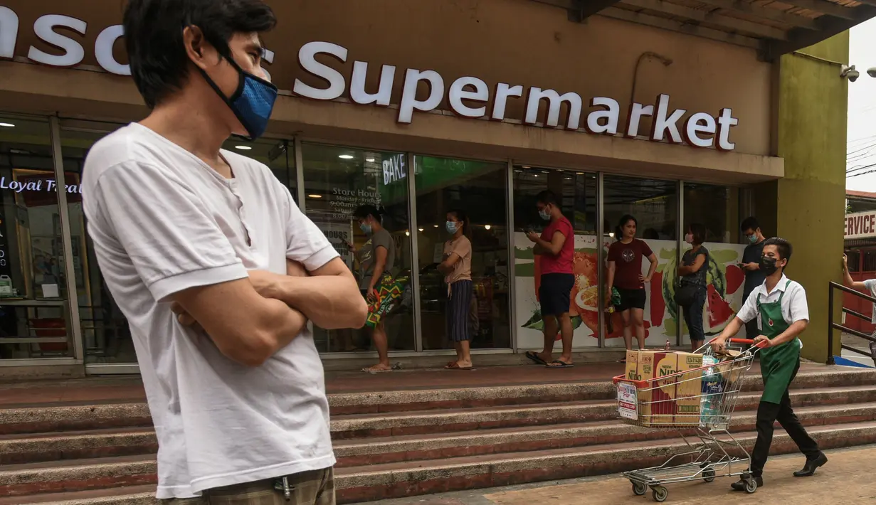 Pembeli berdiri dengan jarak yang aman di garis antrean yang ditempatkan di luar supermarket di Manila, Filipina, Selasa (17/3/2020). Presiden Filipina, Rodrigo Duterte, memutuskan menutup akses keluar dan masuk Manila bagi seluruh jenis transportasi demi mencegah penyebaran virus corona Covid-19. (