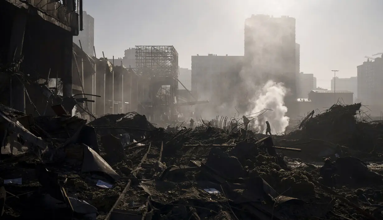 Petugas pemadam kebakaran memadamkan api dekat pusat perbelanjaan setelah serangan sebuah pusat perbelanjaan di Kiev, Ukraina, Senin (21/3/2022). Delapan orang tewas dalam serangan tersebut. (AP Photo/Felipe Dana)
