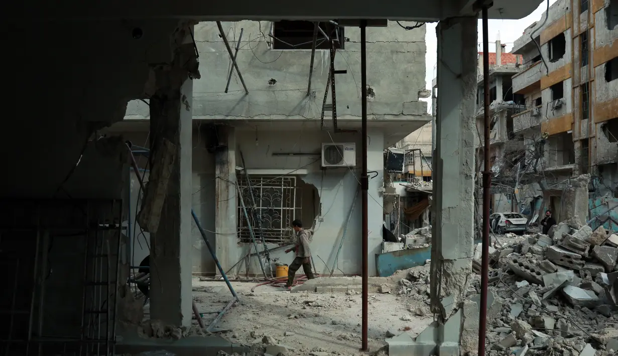 Kondisi bangunan yang hancur akibat  serangan udara dari rezim pemerintah Suriah di Ghouta Timur, Minggu (25/2). Dikuasai pemberontak sejak 2012, Ghouta Timur menjadi benteng terakhir oposisi di sekitar Damaskus. (HAMZA AL-AJWEH/AFP)