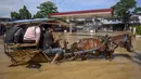 Sebuah kereta kuda mengangkut penumpang melewati jalan yang tergenang banjir melewati sebuah Stasiun Pengisian Bahan Bakar Umum (SPBU) di Bandung, Jawa Barat pada Jumat 5 Desember 2025. Banjir melanda berbagai wilayah di Kabupaten Bandung. Curah hujan tinggi pada Kamis (4/12/2025) sore hari, mengakibatkan aliran sungai Citarum meluap dan merendam sejumlah pemukiman hingga hari ini. (TIMUR MATAHARI/AFP)