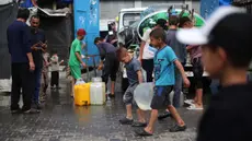 Anak laki-laki Palestina membawa jeriken berisi air dari titik distribusi di kamp pengungsi Bureij, Jalur Gaza tengah pada 28 April 2025. (Eyad BABA/AFP)
