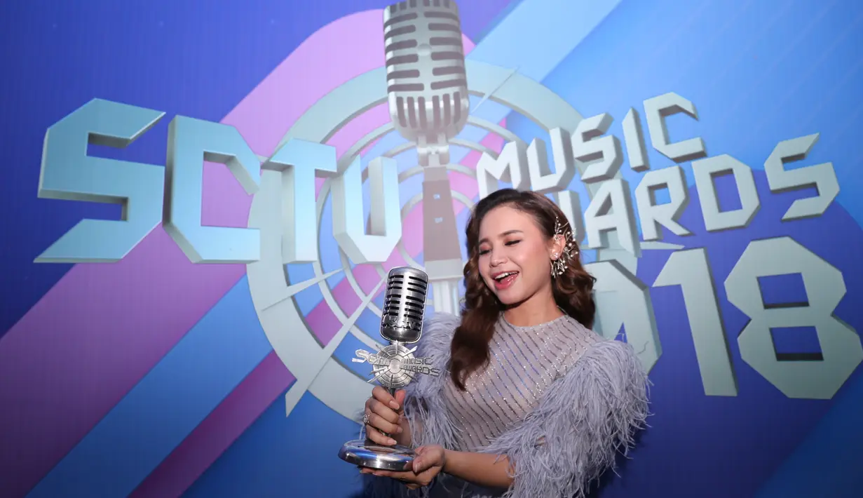 Sederet ekspresi bahagia hadir di wajah Rossa sambil memegang piala berbentuk microphone dan berwarna silver tersebut. Salah satu ekspresinya, terlihat di dalam foto seperti yang satu ini. (Adrian Putra/Bintang.com)