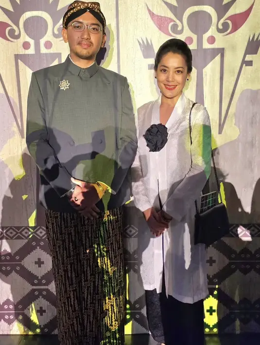 Lulu Tobing tampil menawan dengan kebaya panjang warna putih dipadukan kain hitam sebagai bawahan yang serasi dengan bros bunga besar. [Instagram/@lutob]