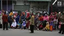 Warga duduk di jalan jelang kirab atau arak-arakan acara resepsi Kahiyang Ayu Siregar-Bobby Nasution di Kota Medan, Sumatera Utara Minggu (26/11). (Liputan6.com/Johan Tallo)