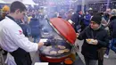 Penjual memasak burger saat Riga Street Food Festival di Riga, Latvia, Sabtu (18/1/2020). Api unggun dan kios-kios makanan didirikan di sudut Jalan Kalku dan Valnu di Kota Tua Riga agar orang-orang dapat menikmati berbagai hidangan populer dari kota tersebut. (Xinhua/Janis)