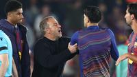 Hansi Flick coba menenangkan pemain Barcelona yang memprotes wasit usai laga kontra Atletico Madrid pada leg 1 perempat final Liga Champions 2025/2026 (Josep LAGO / AFP)