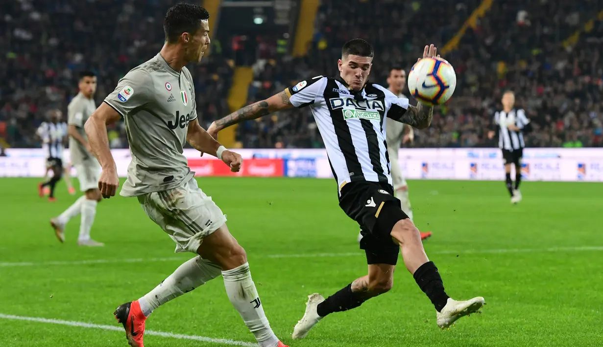 Penyerang Juventus, Cristiano Ronaldo berusaha mengumpan bola dari kawalan pemain Udinese Rodrigo De Paul pada lanjutan Liga Serie A Italia di Stadion Dacia Arena (6/10). Juventus menang 2-0 atas Udinese. (AFP Photo/Miguel Medina)