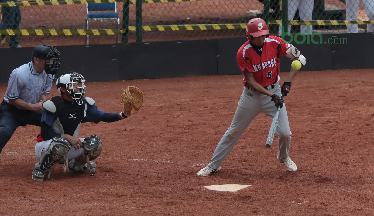 Pemain Singapura, F.Harahap memukul bola mengecoh pemain Taiwan pada laga Asian Softball Championship di Senayan, Jakarta,Selasa (24/4/2018). Singapura menang 12-4. (Bola.com/Nick Hanoatubun)