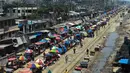 Warga memadati jalan yang dipenuhi lapak pedagang di area pasar tradisional selama karantina wilayah masih diberlakukan pemerintah setempat di Dhaka, Bangladesh (12/5/2020). (AFP/Munir Uz Zaman)