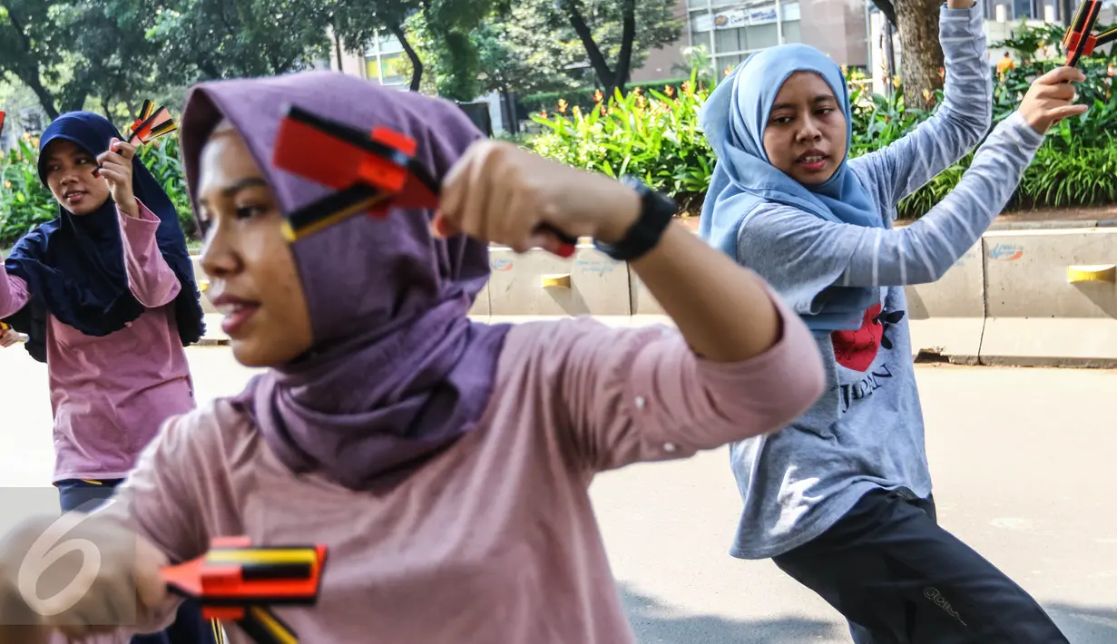 Anak muda yang tergabung dalam komunitas Hyakka Ryouran berlatih alat musik tradisional asal Jepang, Naruko, di kawasan Senayan, Jakarta, Minggu (24/7). Warna alat musik Naruko didominasi warna oranye, kuning dan hitam. (Liputan6.com/Fery Pradolo)