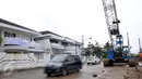 Kendaraan melintas di dekat spanduk penolakan terhadap rencana pembangunan jalan tol di kawasan perumahan Pluit, Jakarta, Kamis (17/12). Penolakan akibat rencana pembangunan jalan layang non tol yang masuk ke pemukiman mereka. (Liputan6.com/Faisal R Syam)