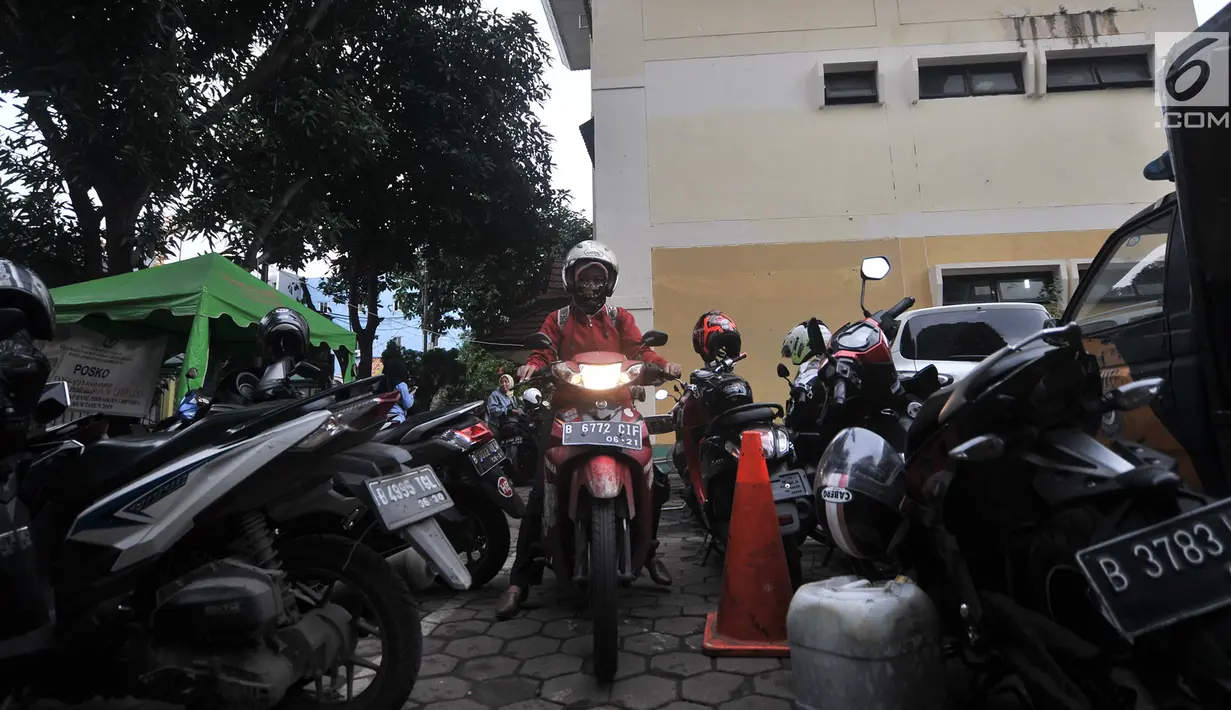 Pegawai kantor Balai Kota DKI Jakarta mengambil motor di Kelurahan Kebon Sirih, Jakarta, Rabu (16/1). Pelarangan pegawai Balai Kota untuk memarkirkan kendaraan di Gedung DPRD menyebabkan halaman Kelurahan penuh dengan motor. (Merdeka.com/Iqbal S Nugroho)