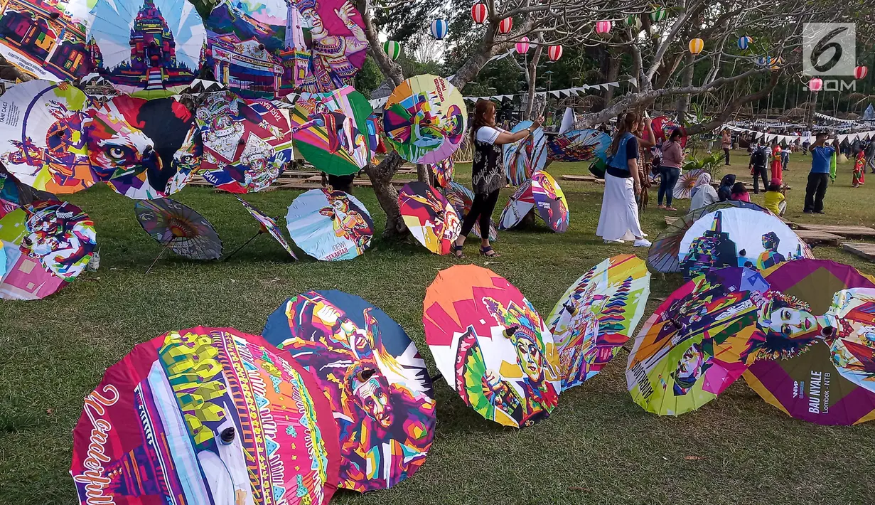 Pengunjung berpose di deretan payung selama Festival Payung Indonesia 2019 di Taman Garuda Mandala, Komplek Candi Prambanan, Kabupaten Klaten, Sabtu ( 7/9/2019). Festival Payung Indonesia 2019 telah berlangsung ke enam kalinya. (Liputan6.com/Gholib)