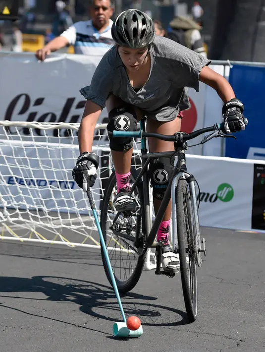 Seorang peserta memukul bola sambil bersepeda saat bermain Polo-Bike pada hari kedua World Bike Forum 2017 di Zocalo Square di Mexico City (20/4). Salah satu kegiatan dalam acara tersebut adalah bermain Polo dengan sepeda. (AFP Photo/Alfredo Estrella)