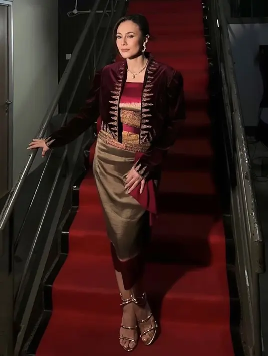 Wulan Guritno tampil mengenakan busana dari Ghea Fashion Studio. Dengan atasan velvet maroon sebagai luaran dengan inner kemben merah dan obi emas serasi dengan roknya. [@ivanteguhsantoso]