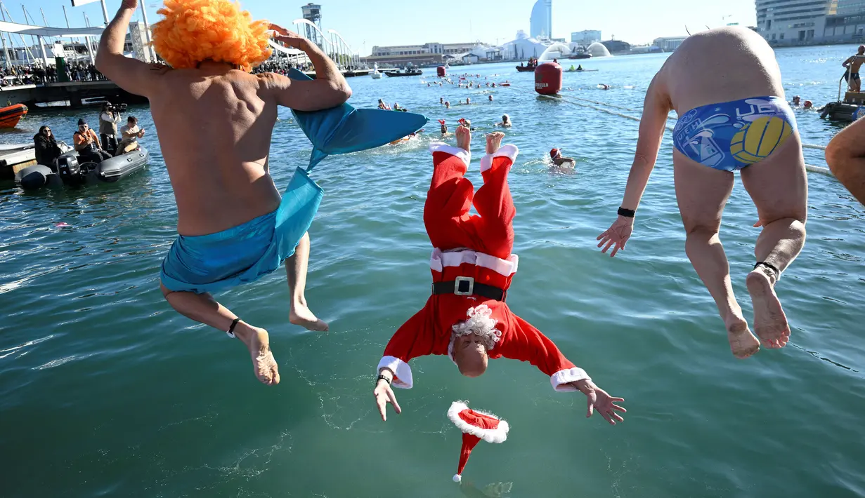 Para peserta tradisi lomba renang unik saat natal di pelabuhan tua Barcelona (Port Vell Barcelona), Spanyol, Senin (25/12/2023) waktu setempat. (AFP/Josep Lago)