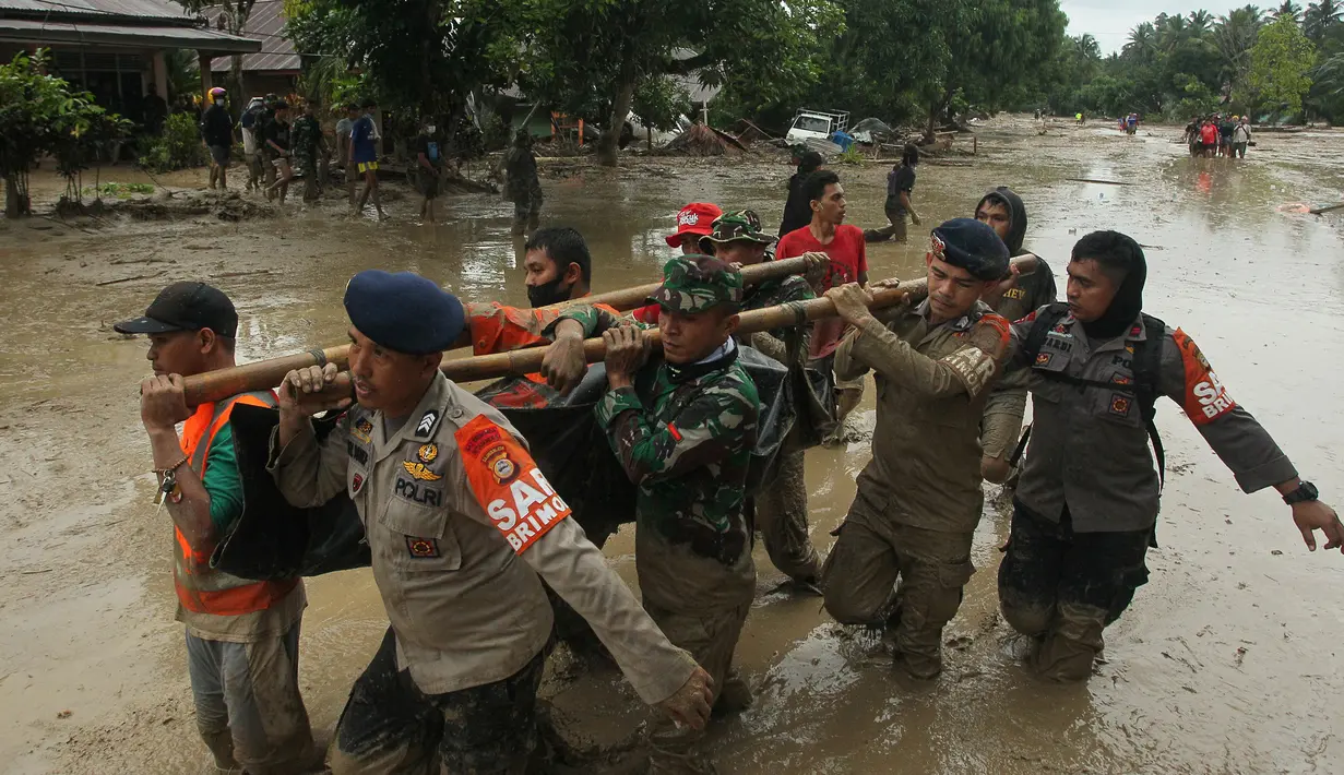 Tim penyelamat membawa mayat korban setelah banjir bandang di desa Radda di Kabupaten Luwu Utara, Sulawesi Selatan (14/7/2020). Lebih dari 4.000 keluarga terdampak akibat kejadian tersebut. (AFP/Aryanto)